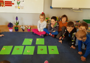 Dzieci rozwiązują zagadki obrazkowe o kwiatach